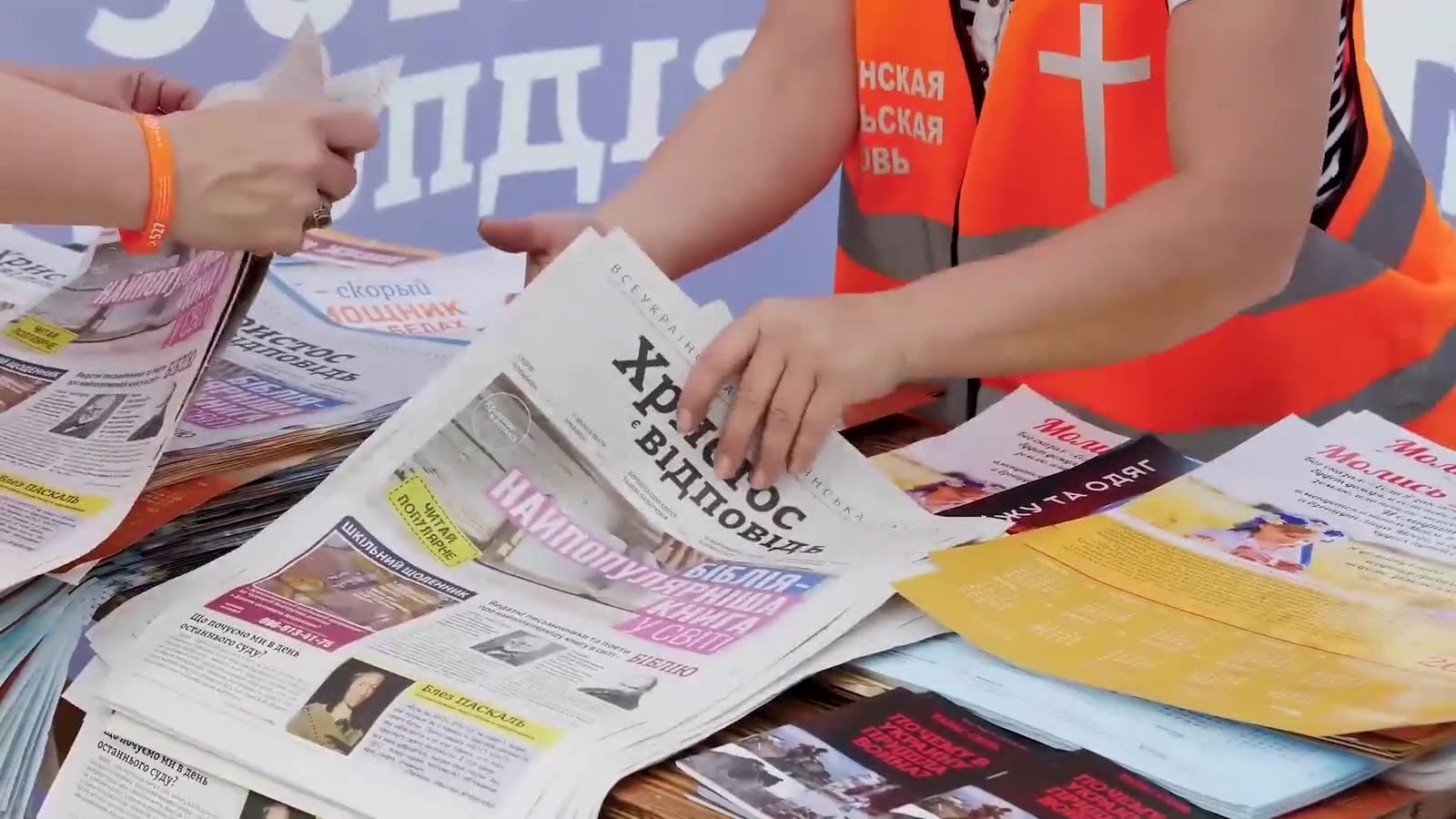 Volunteers handing out the Christ Is the Answer newspaper in Ukrainian.